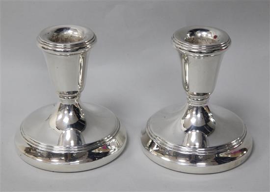 A pair of modern silver dwarf candlesticks, weighted.
